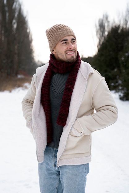 Homme souriant de plan moyen portant des vêtements chauds