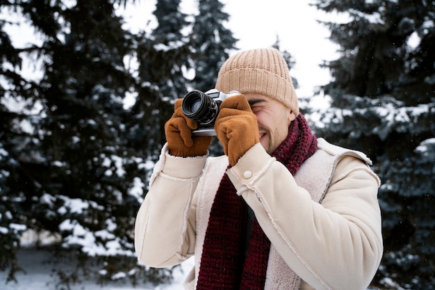 Homme souriant de plan moyen prenant des photos