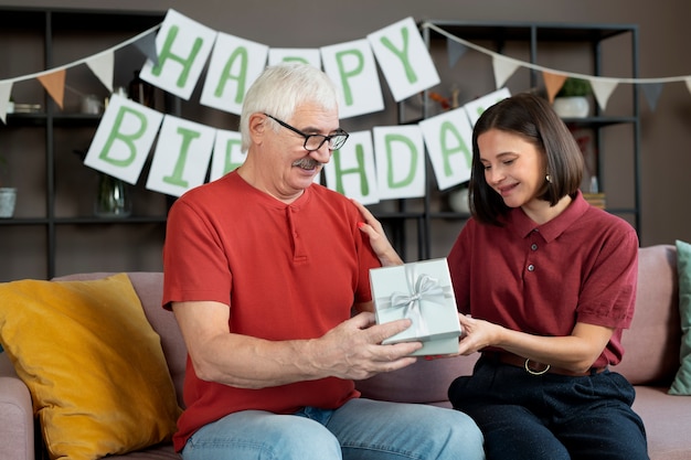 Homme Souriant De Plan Moyen Recevant Un Cadeau