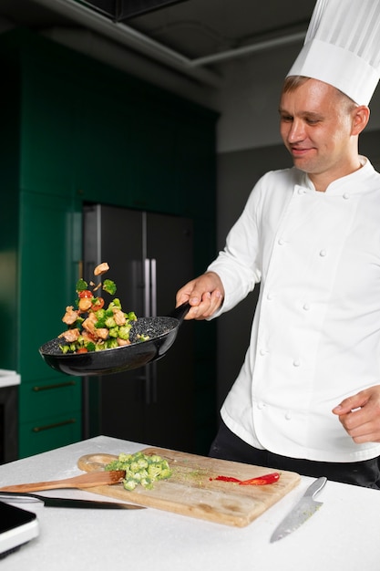 Photo gratuite homme souriant à plan moyen en train de cuisiner