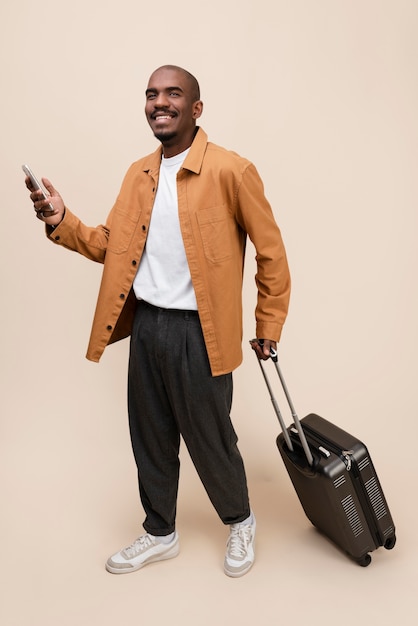 Homme souriant plein coup avec bagages