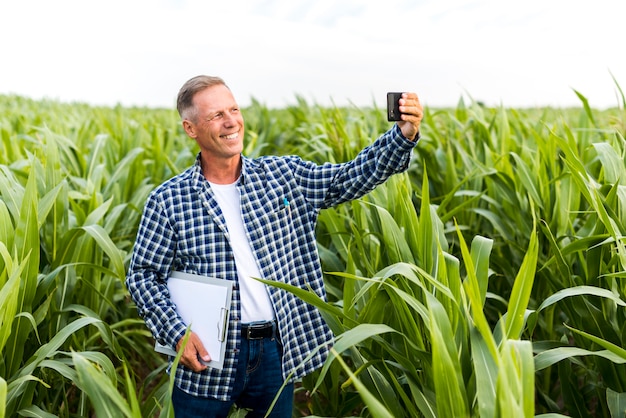 Homme souriant prenant un selfie avec un presse-papier
