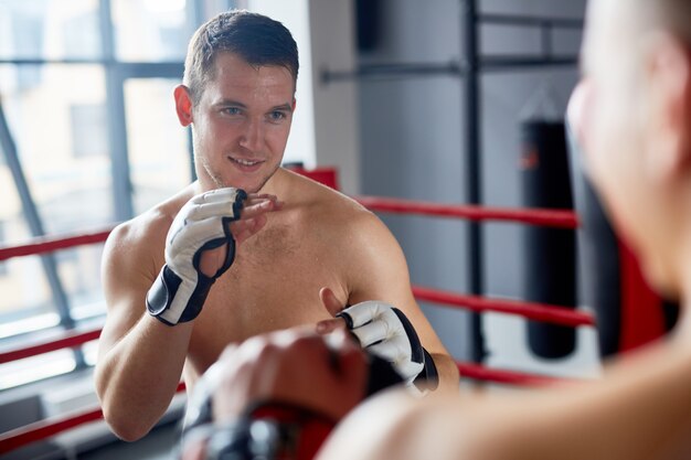 Homme souriant profitant de combat de boxe en ring