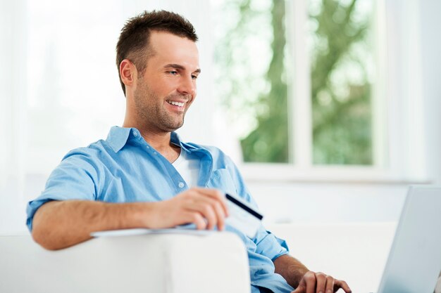 Homme souriant, profitant du commerce électronique