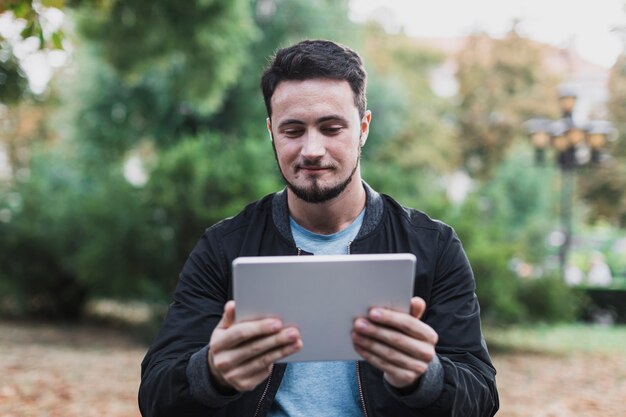 Homme souriant à la recherche dans une tablette