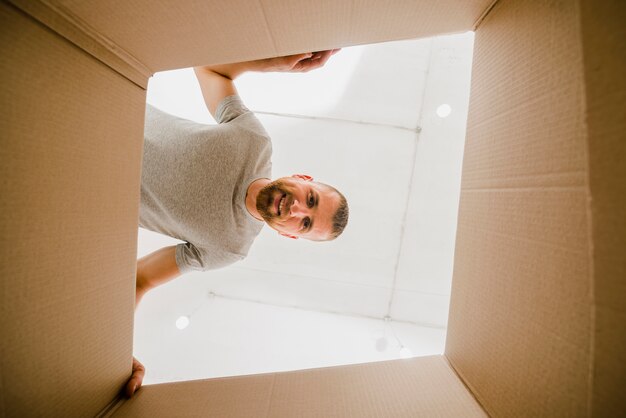 Homme souriant, regardant à l&#39;intérieur de la boîte