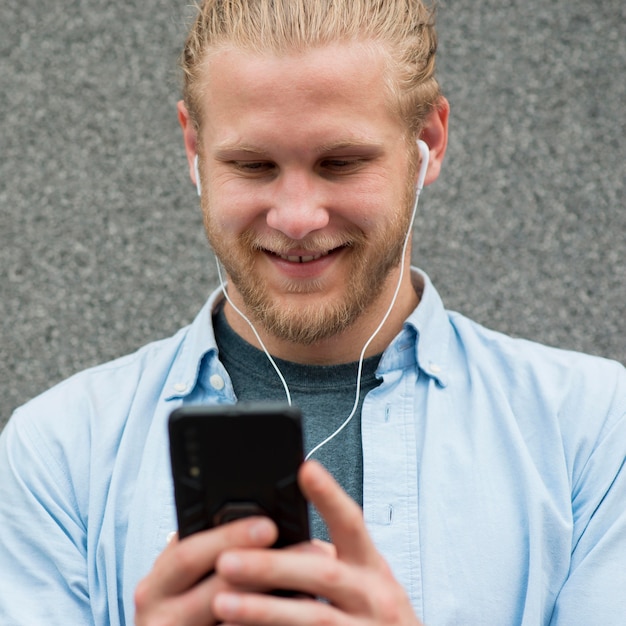 Homme souriant regardant smartphone