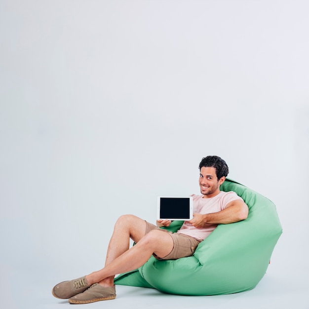 Un homme souriant sur la tablette présentant un canapé