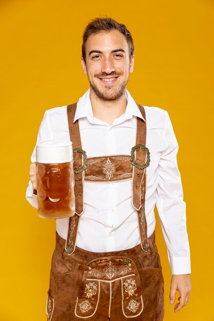 Homme souriant tenant une pinte de bière