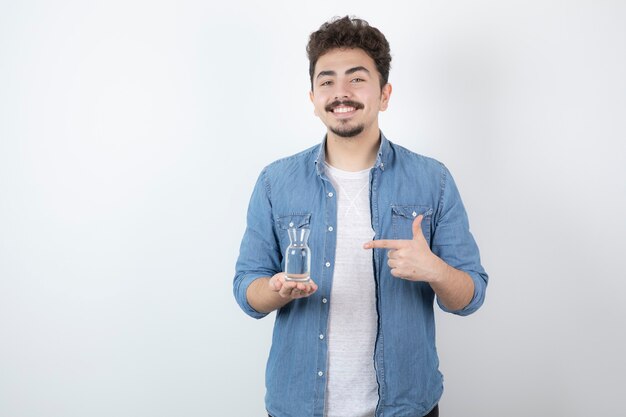 homme souriant tenant un verre d'eau sur blanc.