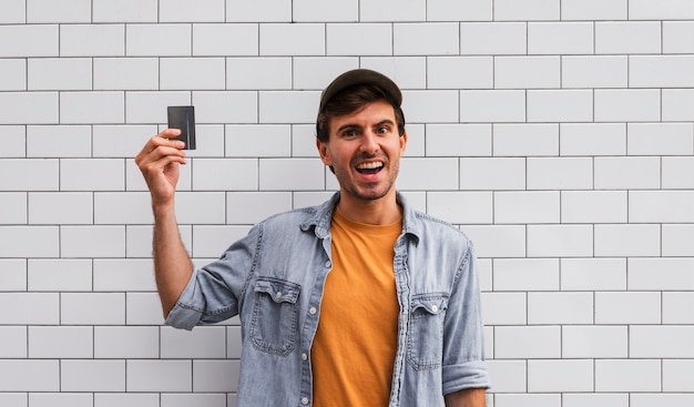 Homme Souriant Tenant La Voiture Sur Le Mur De Fond