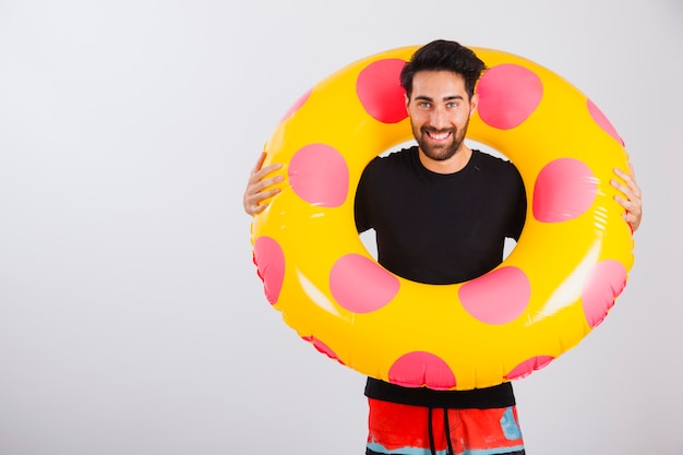 Homme souriant en tenue de plage avec tube flottant