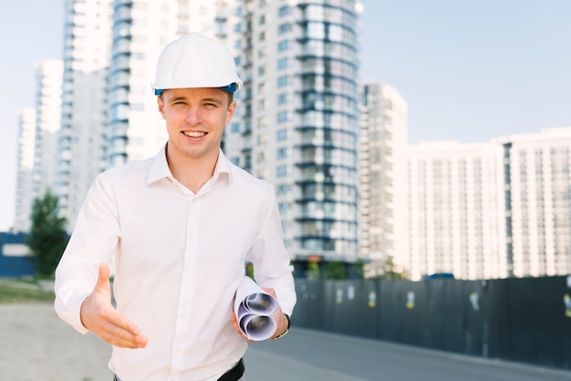 Homme souriant tir moyen tenant des plans