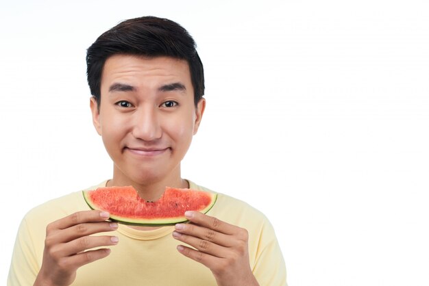 Homme souriant avec une tranche de melon d'eau