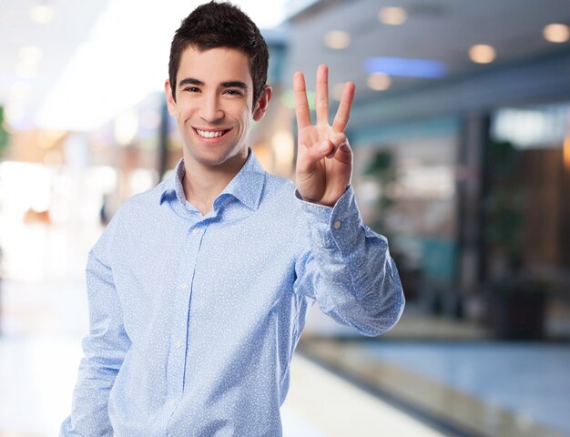 Homme souriant avec trois doigts levés