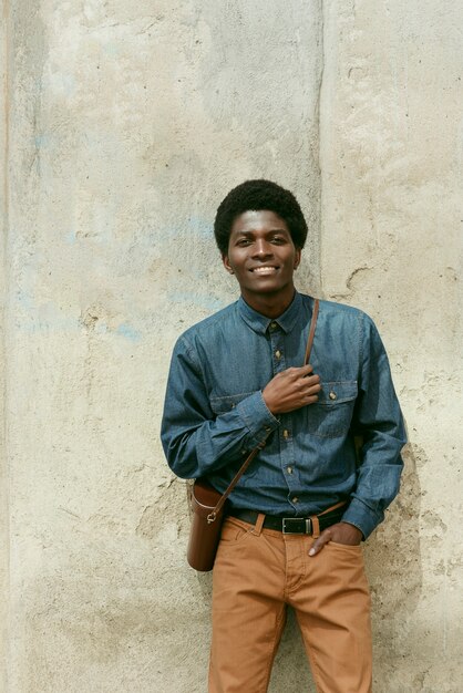 Homme souriant vue de face posant à l'extérieur