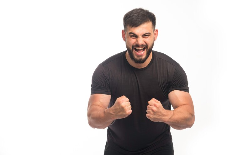 Photo gratuit homme sportif en chemise noire montrant ses triceps et hurlant.