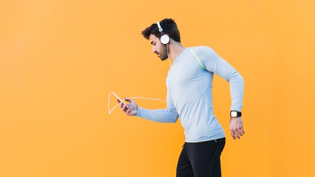 Homme sportif, choisir la musique sur smartphone