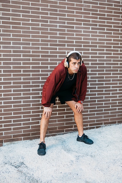 Homme sportif devant le mur de briques