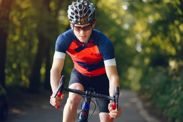 Homme sportif, faire du vélo dans la forêt d'été