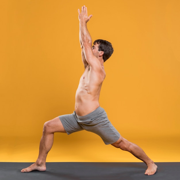 Homme sportif faisant une pose de yoga sur tapis