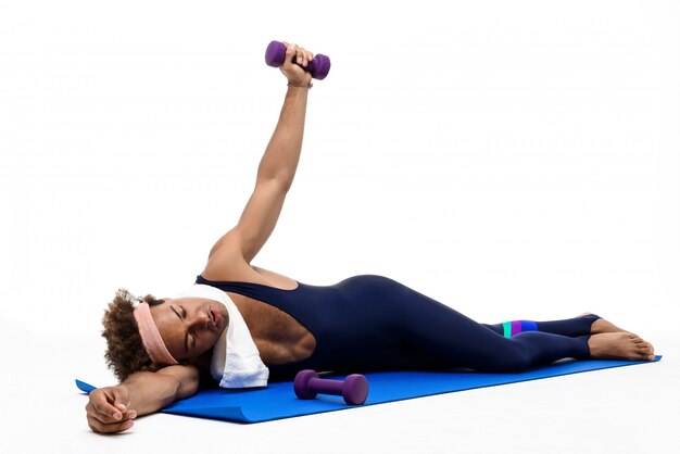 Homme sportif fatigué allongé sur un tapis de yoga