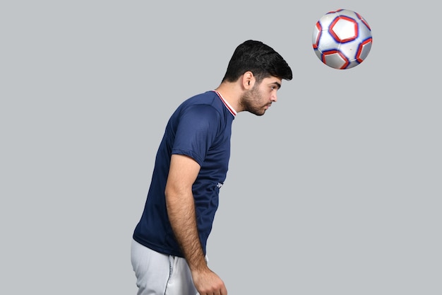 Homme sportif jonglant avec un ballon de football avec tête modèle pakistanais indien