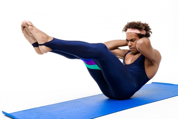 Homme sportif s'entraînant sur un tapis de yoga