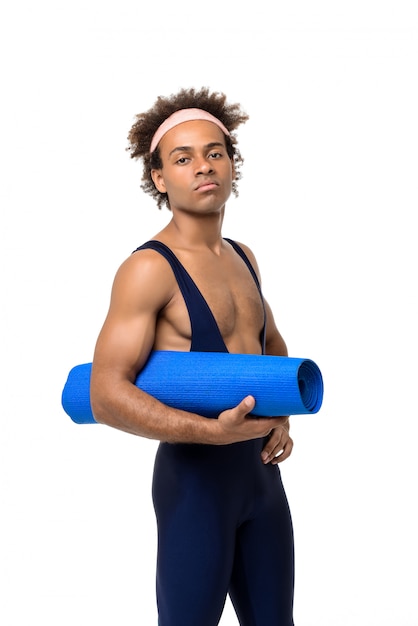 Homme sportif tenant un tapis de yoga