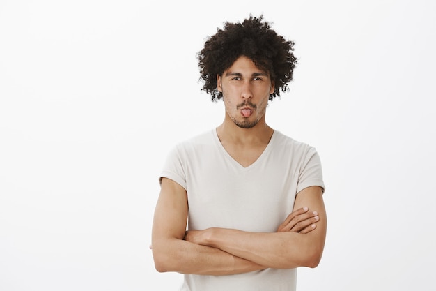 Homme stupide à la peau sombre grimaçant et montrant la langue de l'aversion