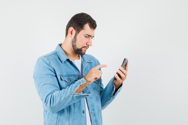 Homme de style rétro appelant quelqu'un en veste, t-shirt et à la recherche de concentré.