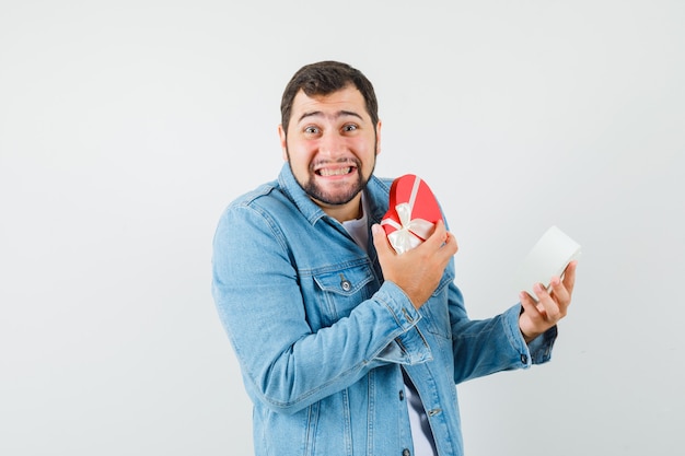 Homme de style rétro à l'intérieur de la boîte en veste, t-shirt et à l'air heureux. vue de face.