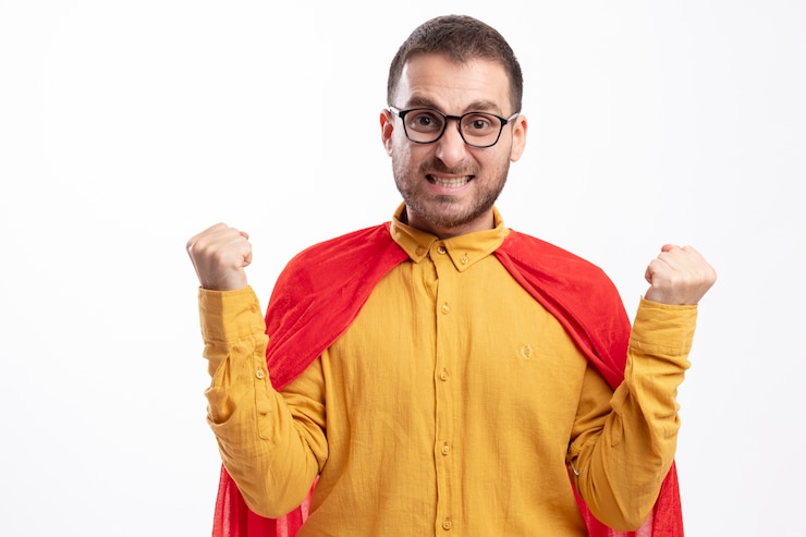 Photo gratuit homme de super-héros anxieux dans des lunettes optiques avec manteau rouge garde les poings isolés sur un mur blanc