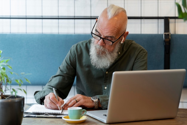 Homme supérieur de coup moyen prenant des notes