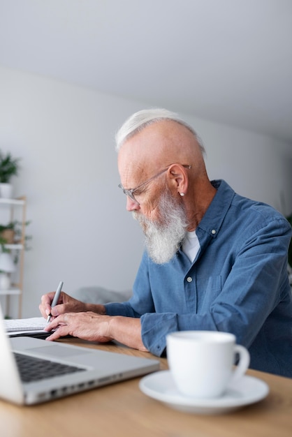 Photo gratuite homme supérieur de coup moyen prenant des notes