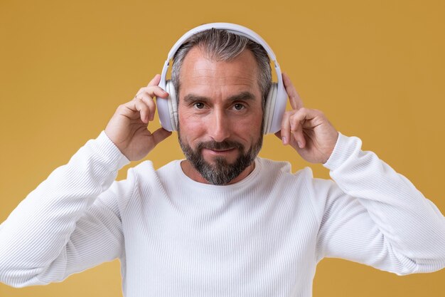 Homme supérieur écoutant de la musique avec des écouteurs