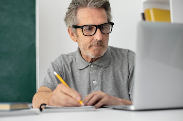 Homme supérieur faisant des cours en ligne sur un ordinateur portable