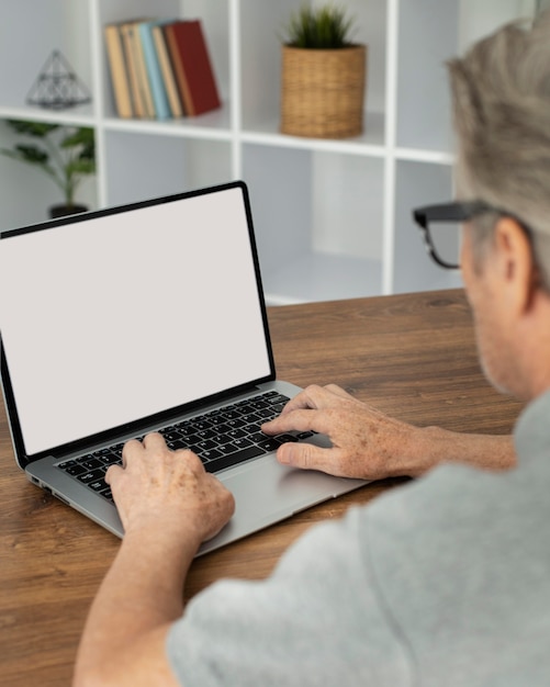 Homme supérieur faisant des cours en ligne sur un ordinateur portable