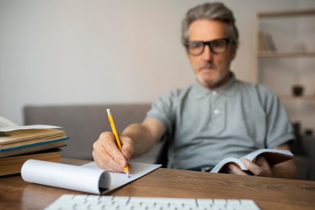 Homme supérieur prenant des notes en classe