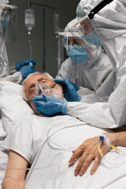 Photo gratuite homme supérieur respirant avec un équipement spécial à l'hôpital