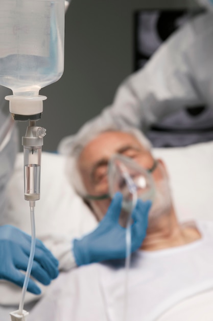 Homme supérieur respirant avec un équipement spécial à l'hôpital