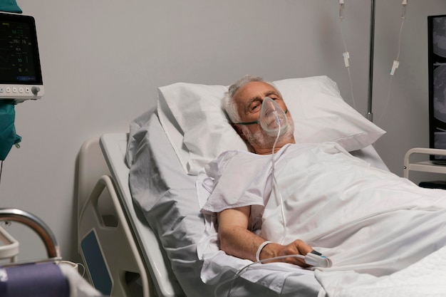 Photo gratuite homme supérieur respirant avec un équipement spécial à l'hôpital