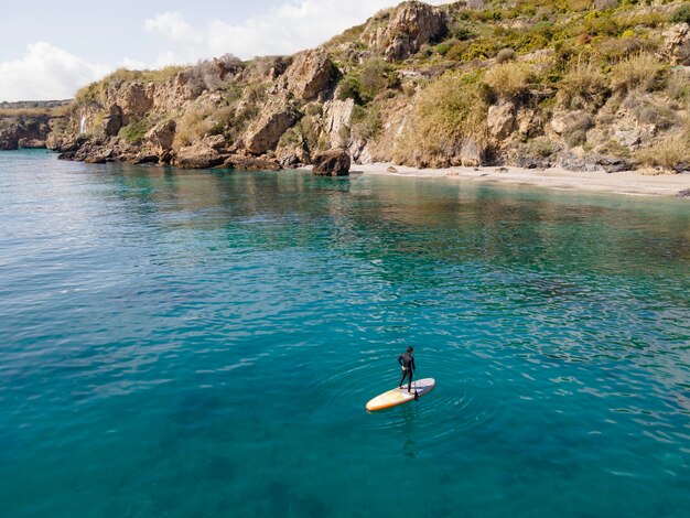 Homme surf avec belle vue long shot