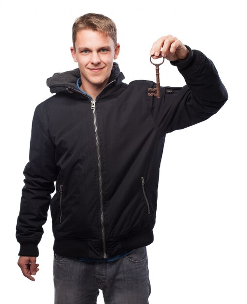 Homme avec sweat tenant une vieille clé