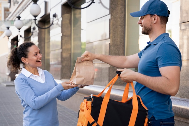 Photo gratuite homme en t-shirt livrant des plats à emporter