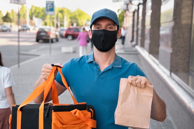 Photo gratuite homme en t-shirt livrant des plats à emporter