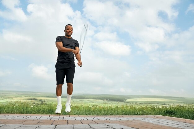 Homme en t-shirt noir et short sautant