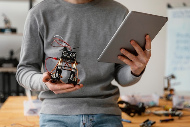 Homme avec tablette apprenant à faire du robot se bouchent