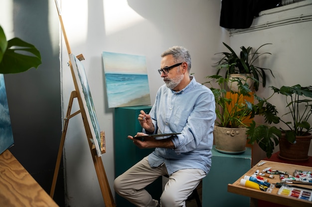 Un homme de taille moyenne peint des aquarelles.