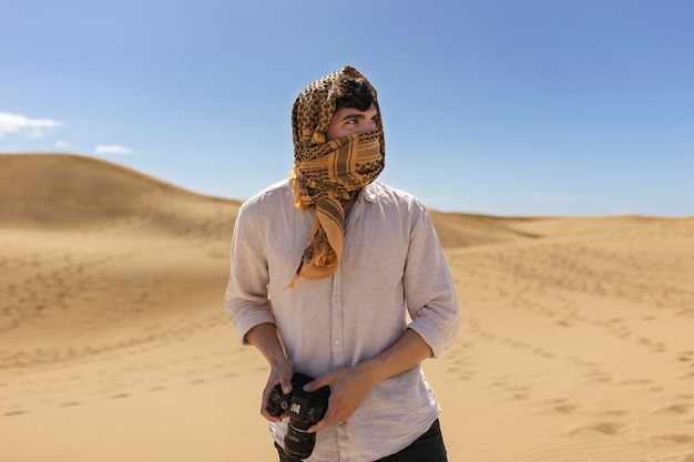 Un homme de taille moyenne tenant une caméra photo.